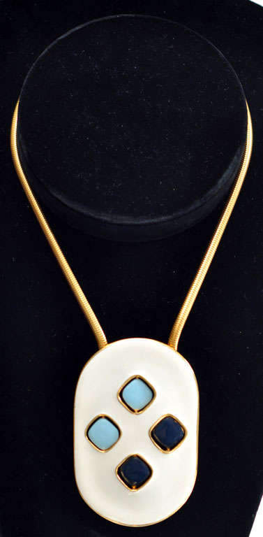 Enameled white pendant with reversible design.  Wearer is able to 