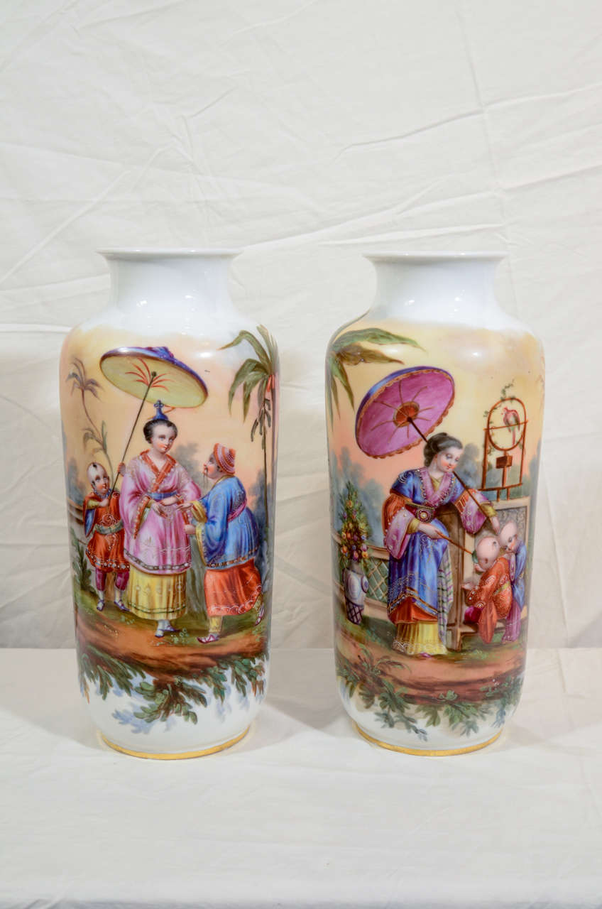 A standout pair of late 19th century or early 20th century porcelain vases painted with chinoiserie scenes.  Both vases show a colorful scene with a beautiful, young, European woman wearing Chinese dress. These attractive and imaginative scenes