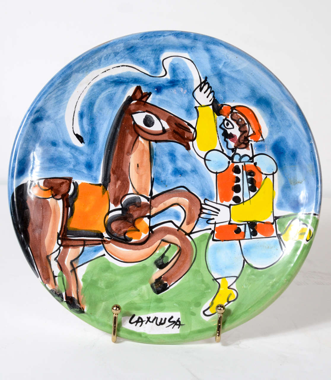 Hand painted Picasso style art pottery plate from La Musa pottery of Italy. Vivid, bright colors. Titled: Carnivale
La Musa opened in 1949. This plate is in the 1960's whimsical style made popular at that time by Giovanni Desimone and Pablo