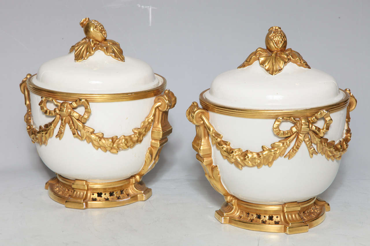 Une paire de rafraîchisseurs de fruits en porcelaine de style Louis XVI. Une paire assortie telle que celle-ci est extrêmement rare. Des guirlandes et des rubans dorés en relief décorent les côtés et complètent la couleur blanche mate de la