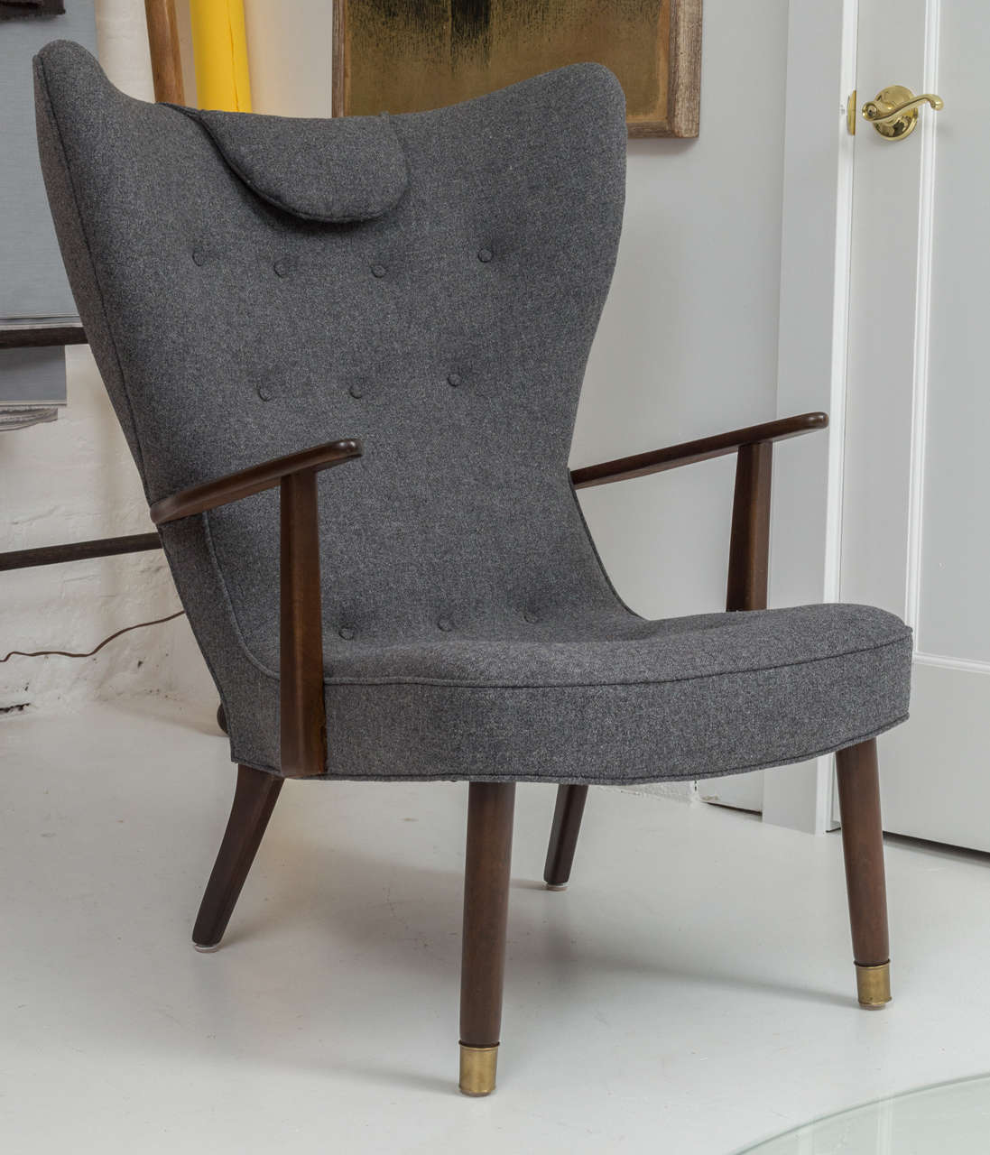 Beautiful vintage wing chair. Completely refurbished with new Maharam wool upholstery and refinished frame. Brass feet caps and padded head rest.