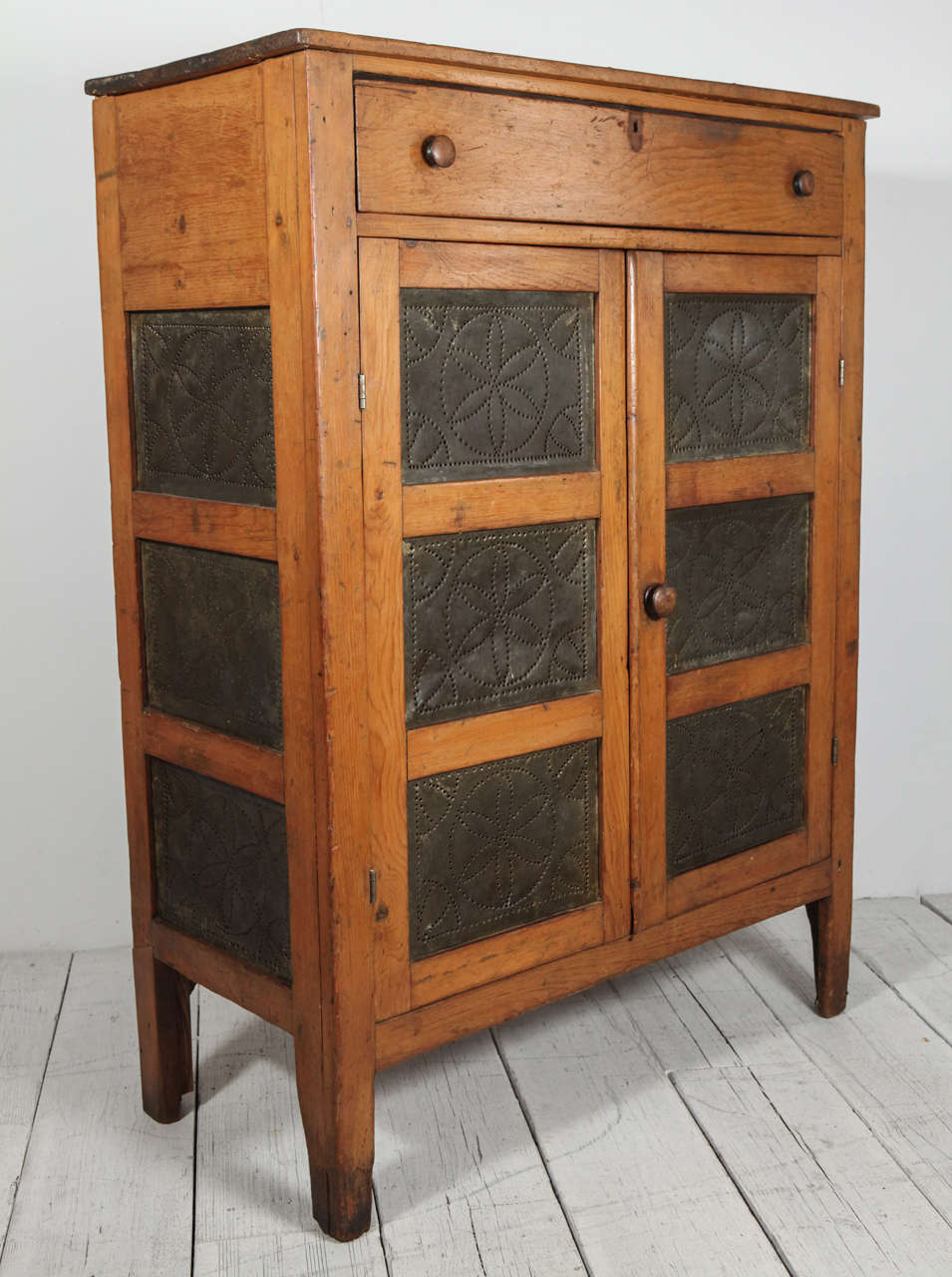 Rustic pie safe in antique condition. Doors and sides have three decoratively perforated ventilation panels.