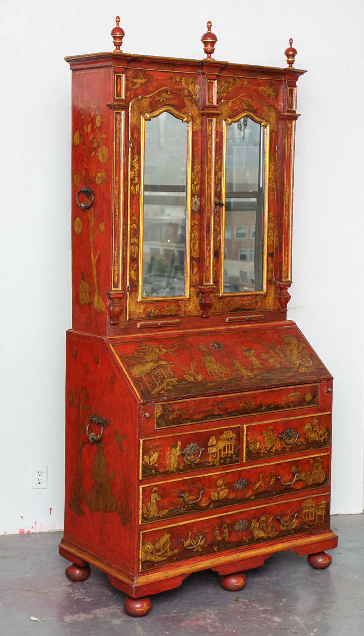Important Venetian Red Chinoiserie Japanned Bureau Bookcase, having a stepped and molded cornice with turned finials above a pair of arched glazed doors with candle slides below, the doors opening to reveal an arrangement of compartments with