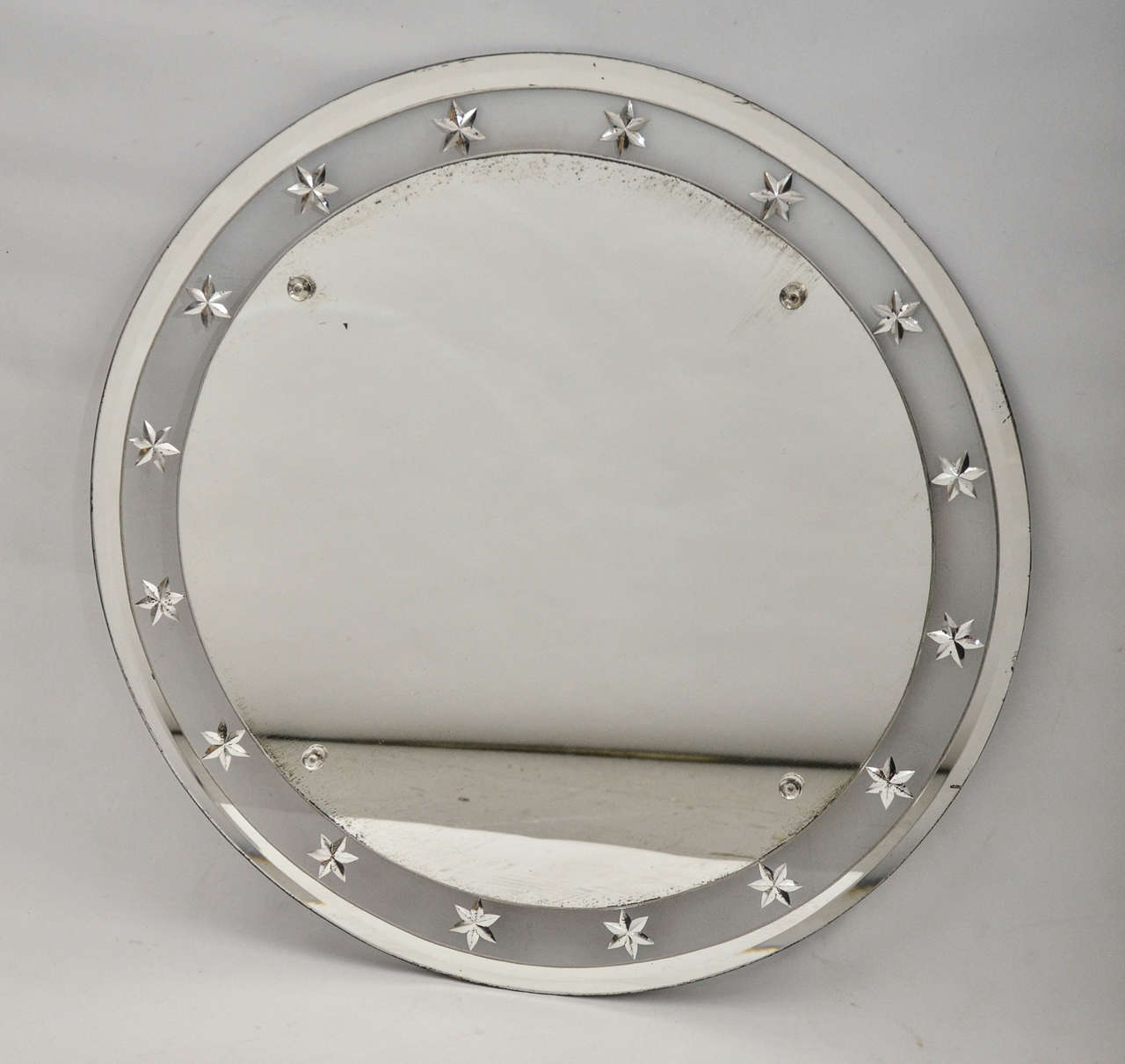 Federal inspired round mirror with star detail inlaid in glass around border.