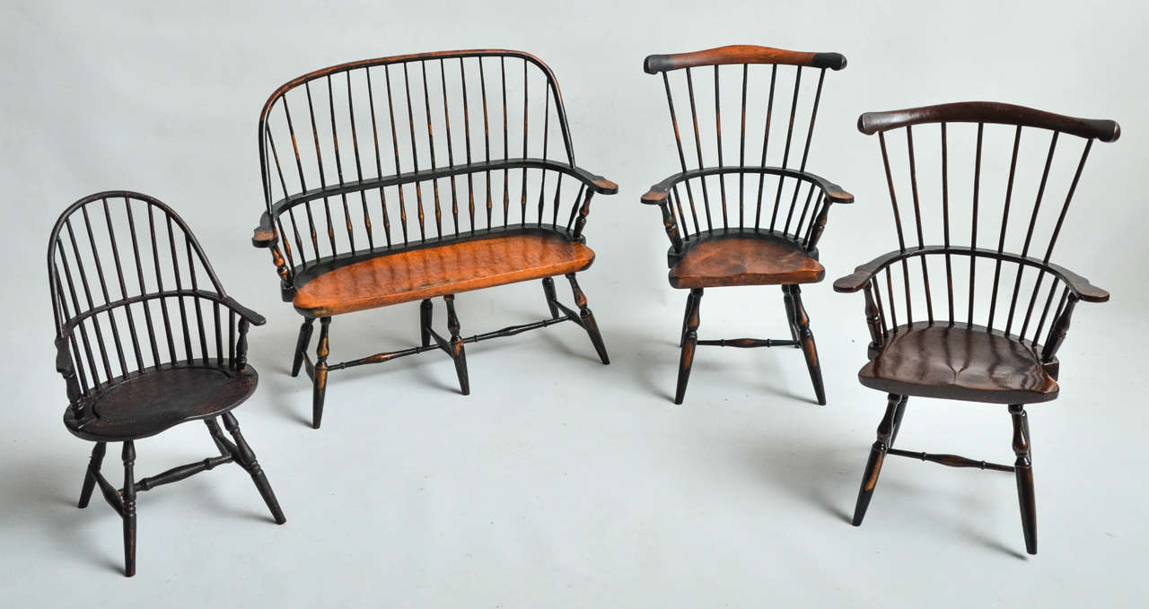 A unique set of doll seating made of wood consisting of a bench and three side chairs.