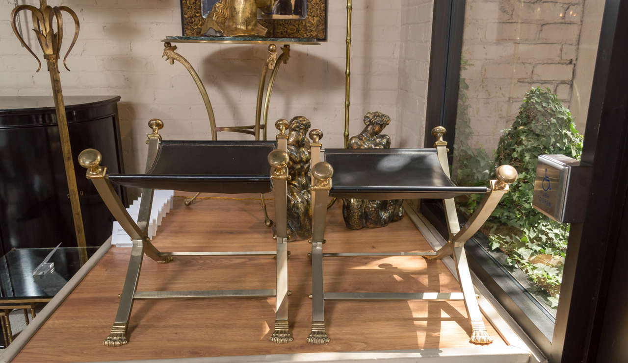 A chic pair of neoclassical, steel and brass, folding campaign stools with black leather seats 
Circa 1970.