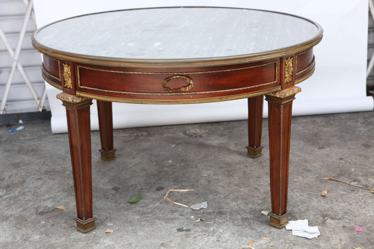 très belle table basse en noyer français avec un seul tiroir, montée en bronze, datant de 1900.  Le marbre gris est d'origine.