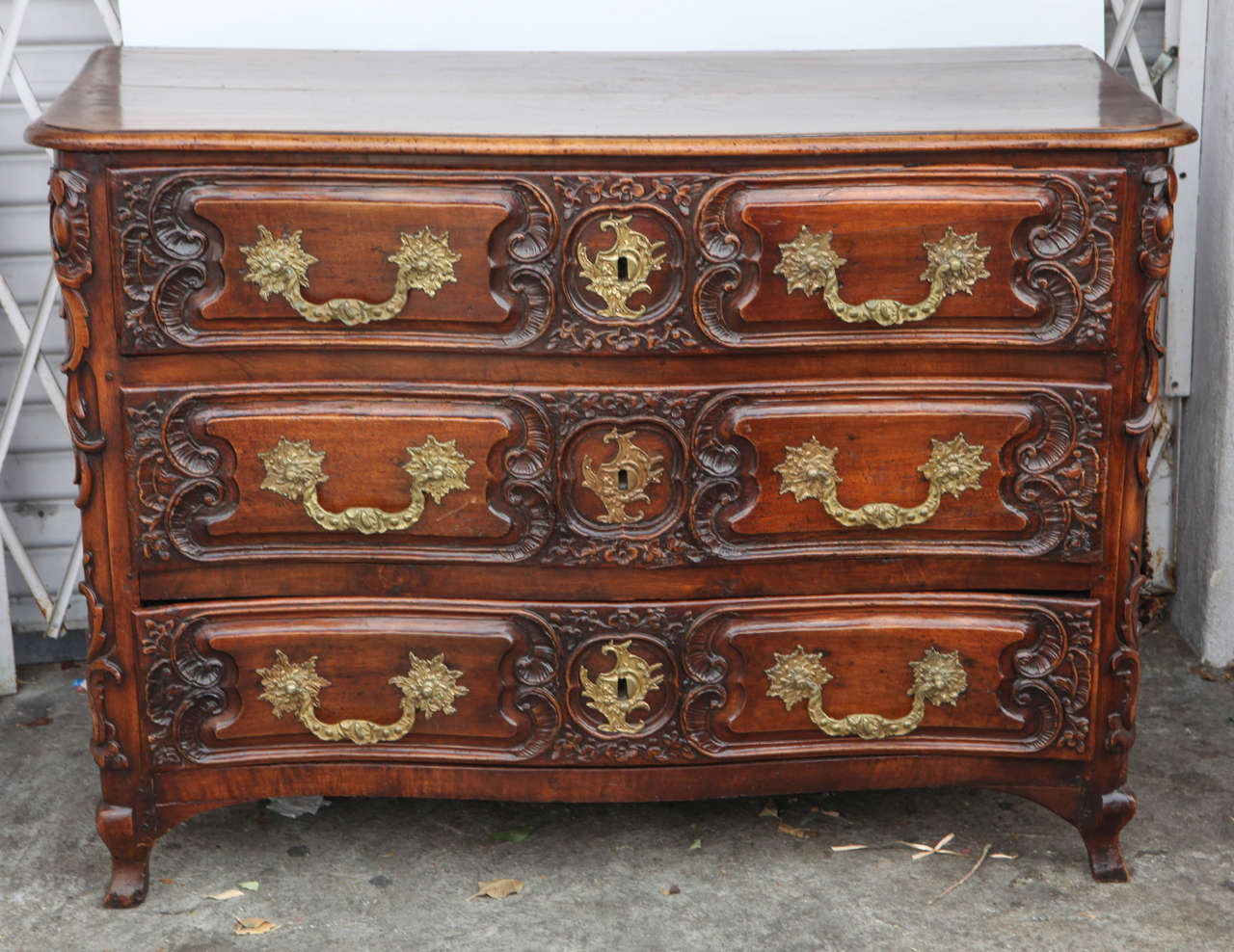 18th century French Louis XV style finely carved walnut three-drawer commode with bronze hardware. Lyon, France.
