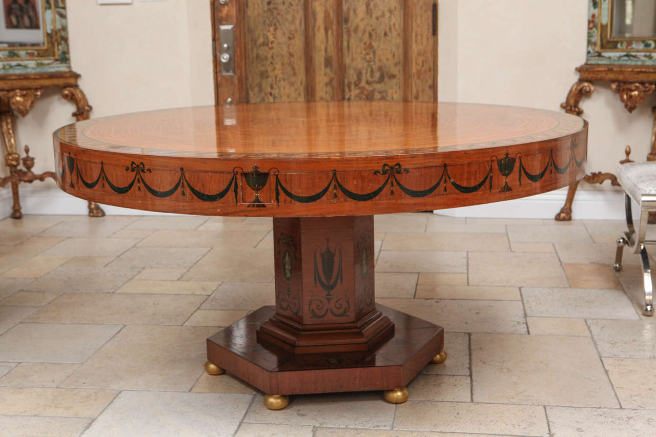 Late 19th century Edward Caldwell very rare round hand-painted satinwood dining table with doré bronze bun feet. Original bronze screws attach the four leaves. Once leaves are attached the table is 72 inches in diameter. Please see the matching
