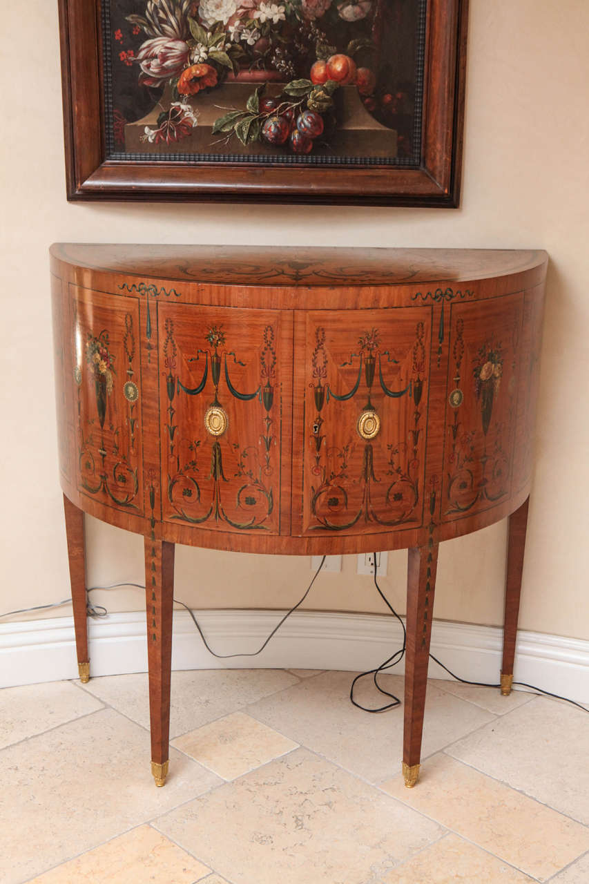 Late 19th century Edward Caldwell satinwood demilune console table with doré bronze feet and handles. This magnificent demilune or console table is very finely painted and matches our dining table also available on our 1st dibs storefront.