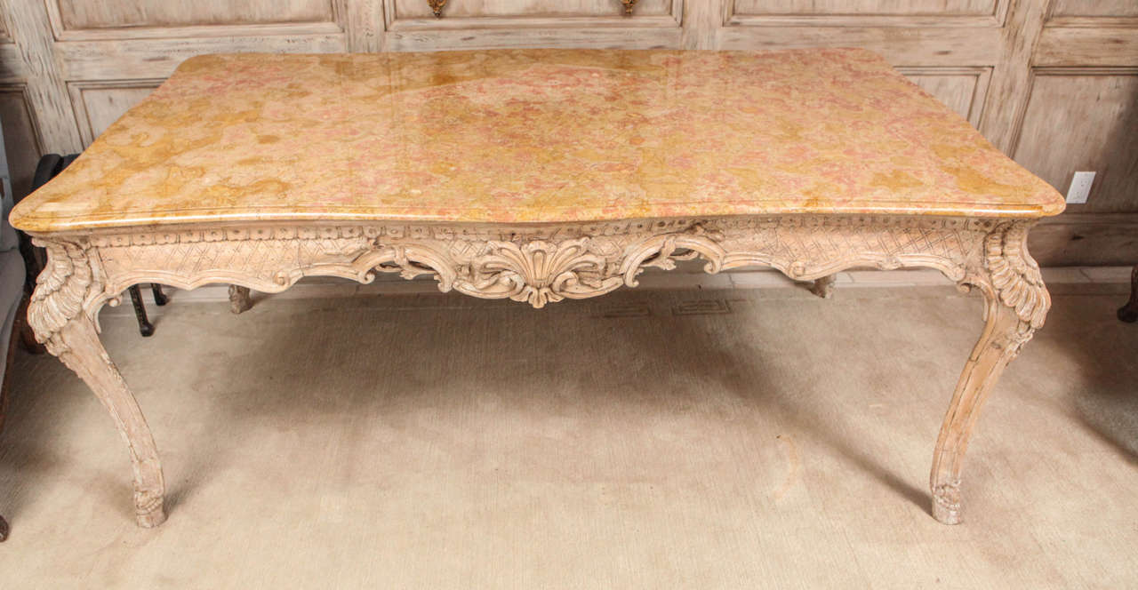 19th century French Louis XIV style center table with Siena marble top. The table is painted and has a finely carved shell motif and hoof feet. The table can be floated in the middle of a room as it is carved on all sides. The Siena marble top is