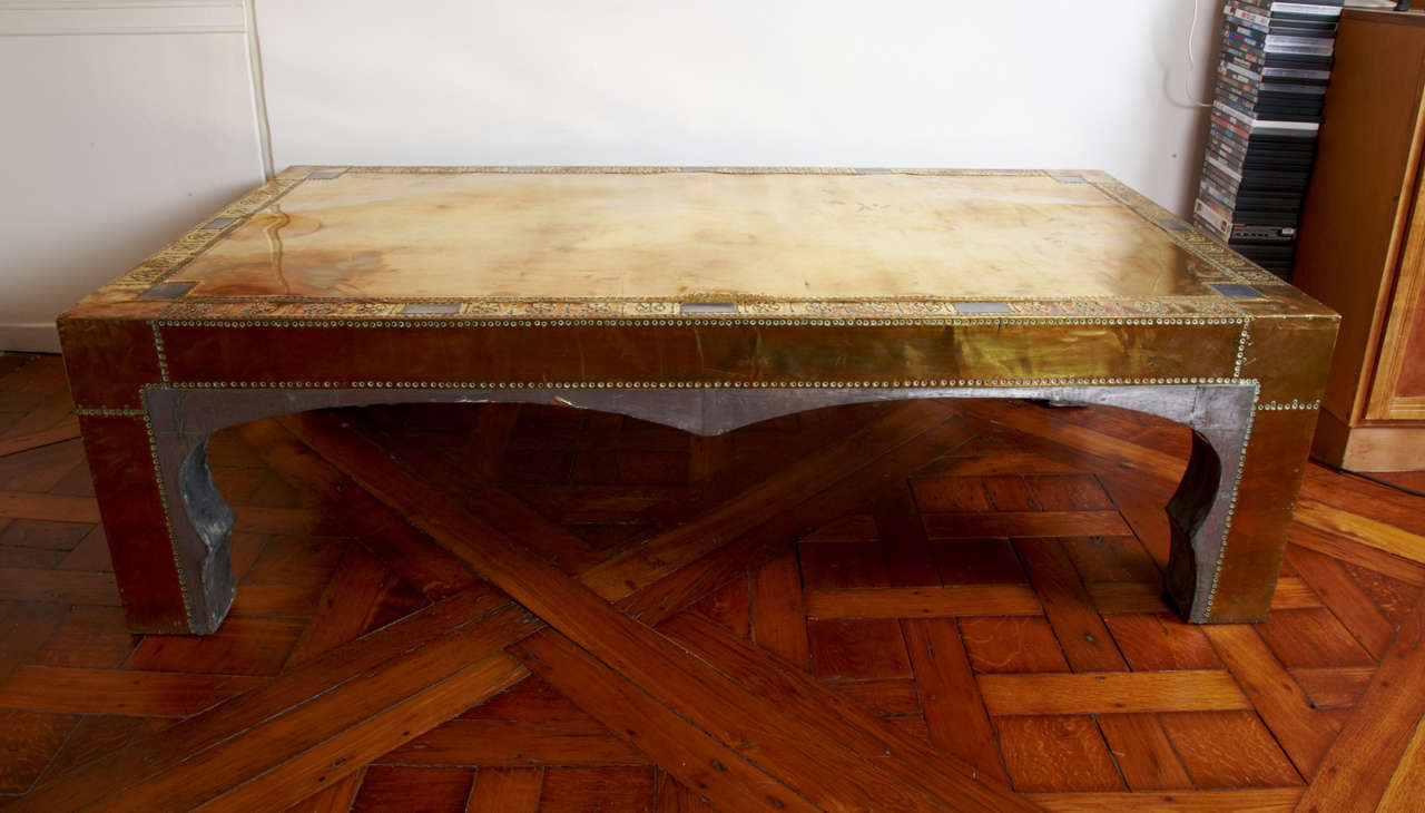 A RODOLFO DU BARRY MASSIVE MID CENTURY ORIENTALIST  COFFEE TABLE MADE OF WOOD,FULLY  COVERED WITH SHEETS OF BRASS AND SHEETS OF  ZINC.
LOTS OF EMBOSSED  BRASS DETAILS .
Rodolfo du Barry,frenche designer ,based in Paris and Marbella  designed the