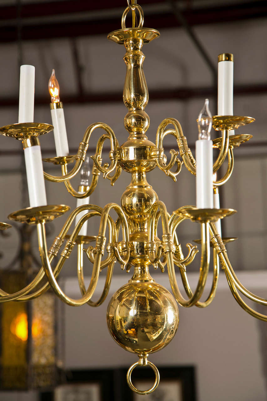 Georgian style chandelier. The central support comprised of a group of four circular balls with a set of twelve sprawling curved arms all ending in lighted fixtures.