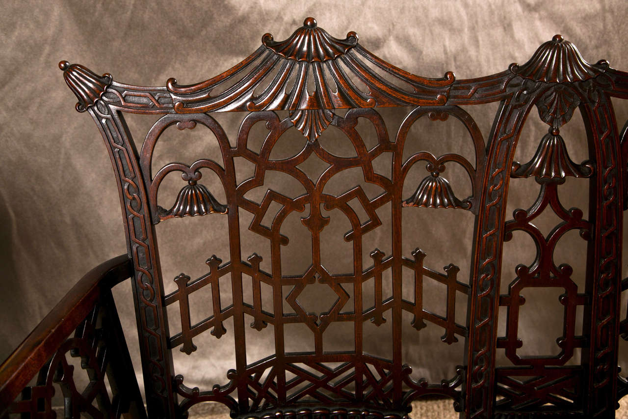 Fine 19th Century Chinese Chippendale Settee with  Upholstered Seat. Fine bamboo carved legs support a carved apron with a custom upholstered seat. Tthe overall back and arm rests with all over carved fret wood design. The top ending in a pagoda