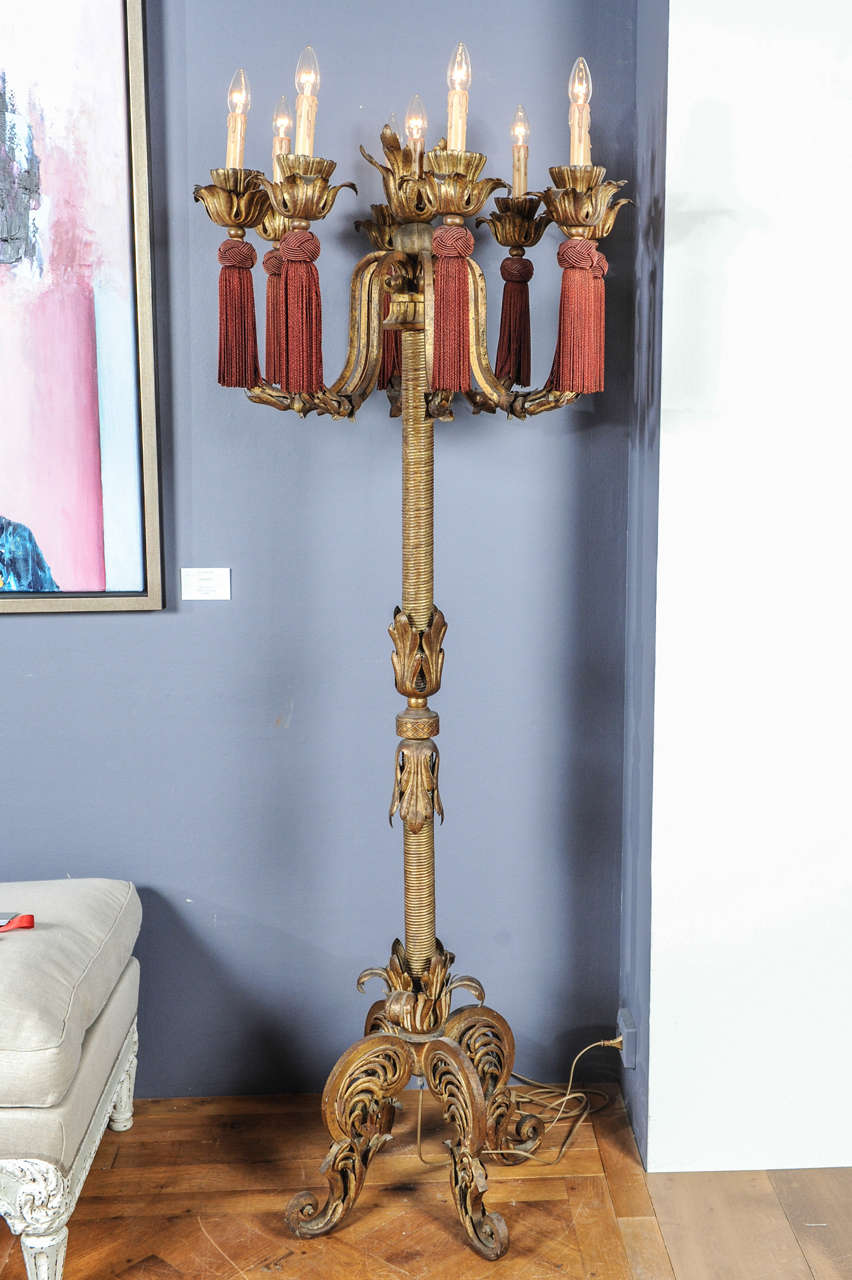 Gilt wrought iron with red tassels. The torchere has been rewired.