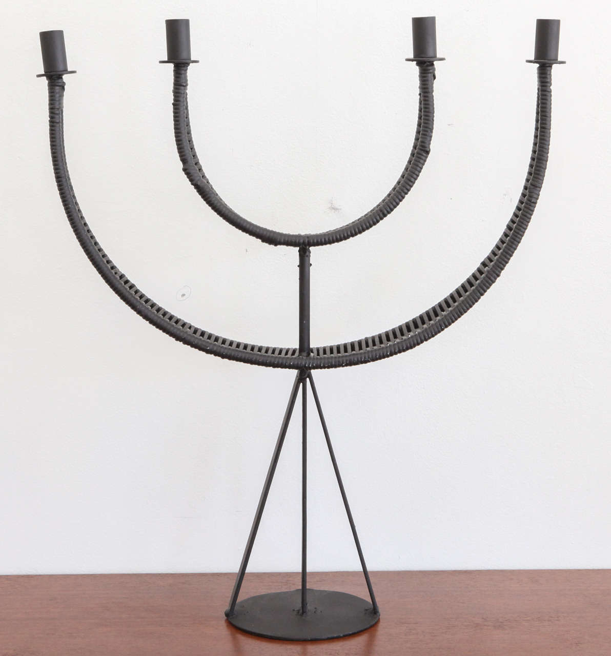 Made of wrought iron and rattan, this Arthur Umanoff for Raymor candleholder makes for a wonderful centerpiece on your dining table, whether al fresco or otherwise! It's a fantastic example of classic mid-century design.