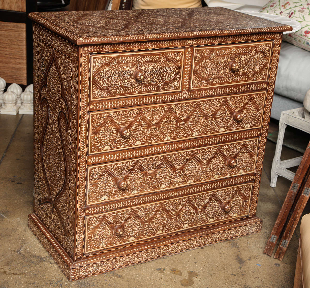 A wood chest of drawers with bone inlays in a classic pattern from India and five drawers.