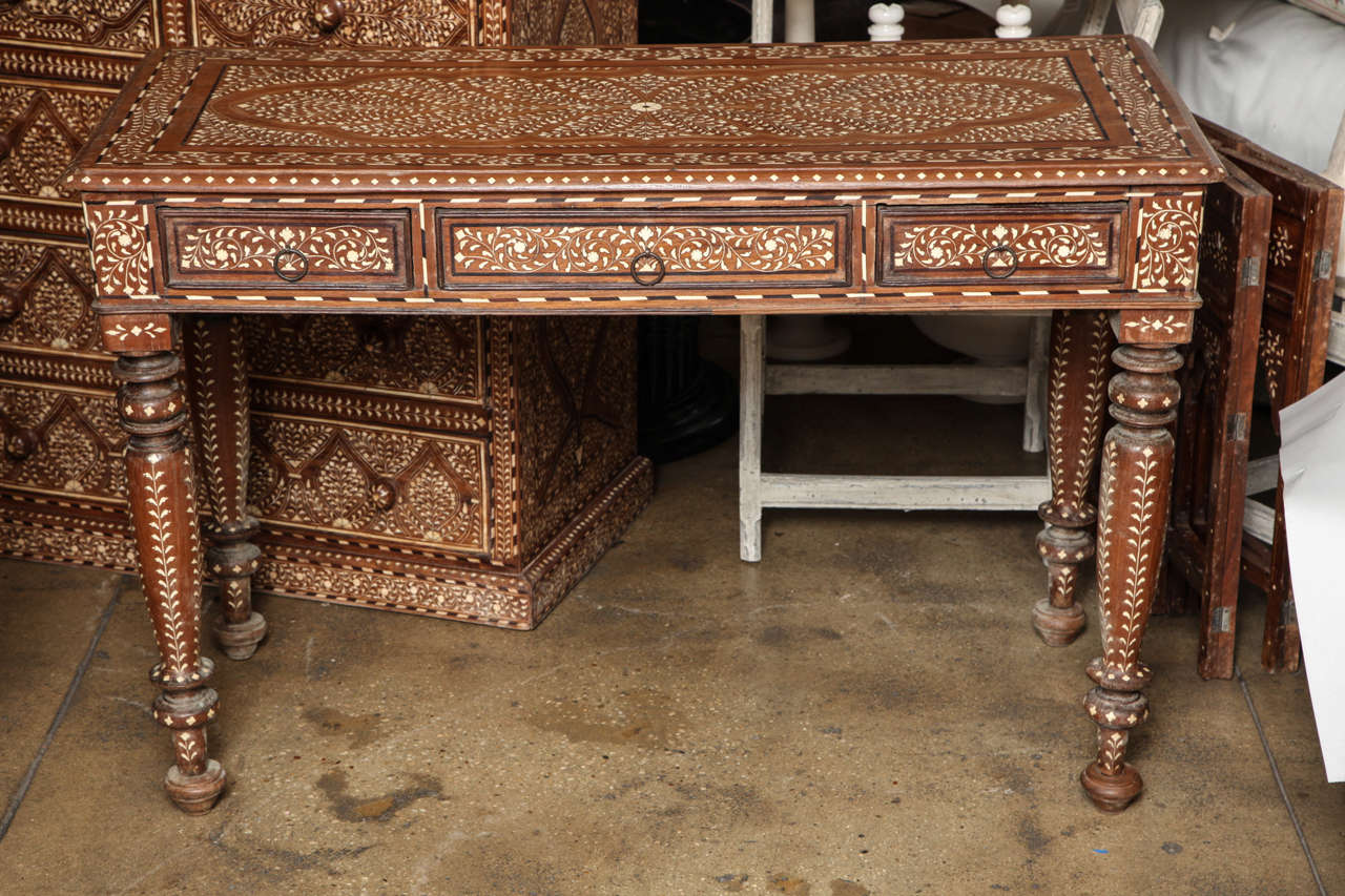 A wood desk with bone inlays in a classic pattern from India.  Three drawers.