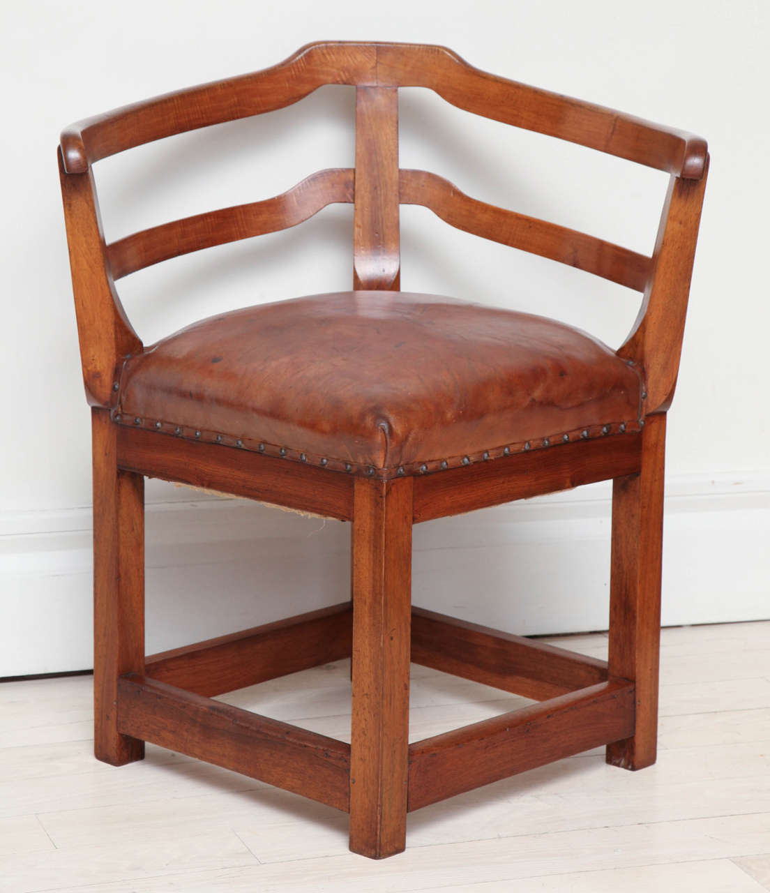 Early 1800's walnut corner chair with slat back and original brown leather seat.