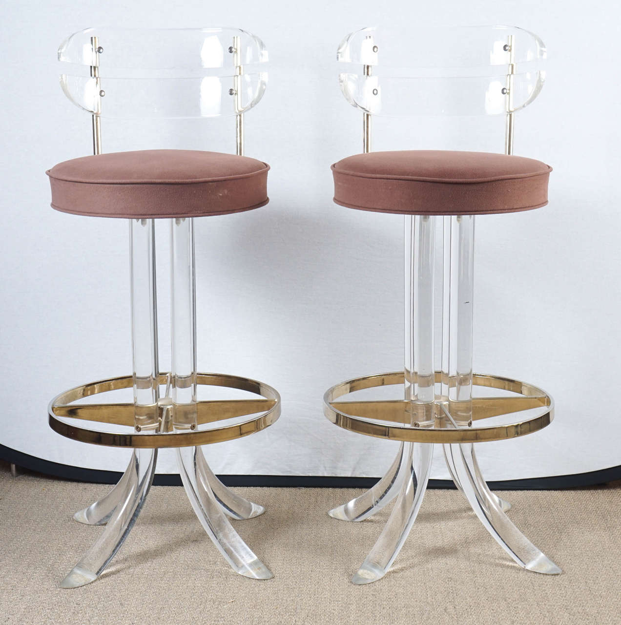 Here is a great pair of lucite barstools with brass detail in the style of Charles Hollis Jones. The lucite is very thick and heavy and in sturdy condition.
The seats should be re upholstered but are clean with light spotting.
