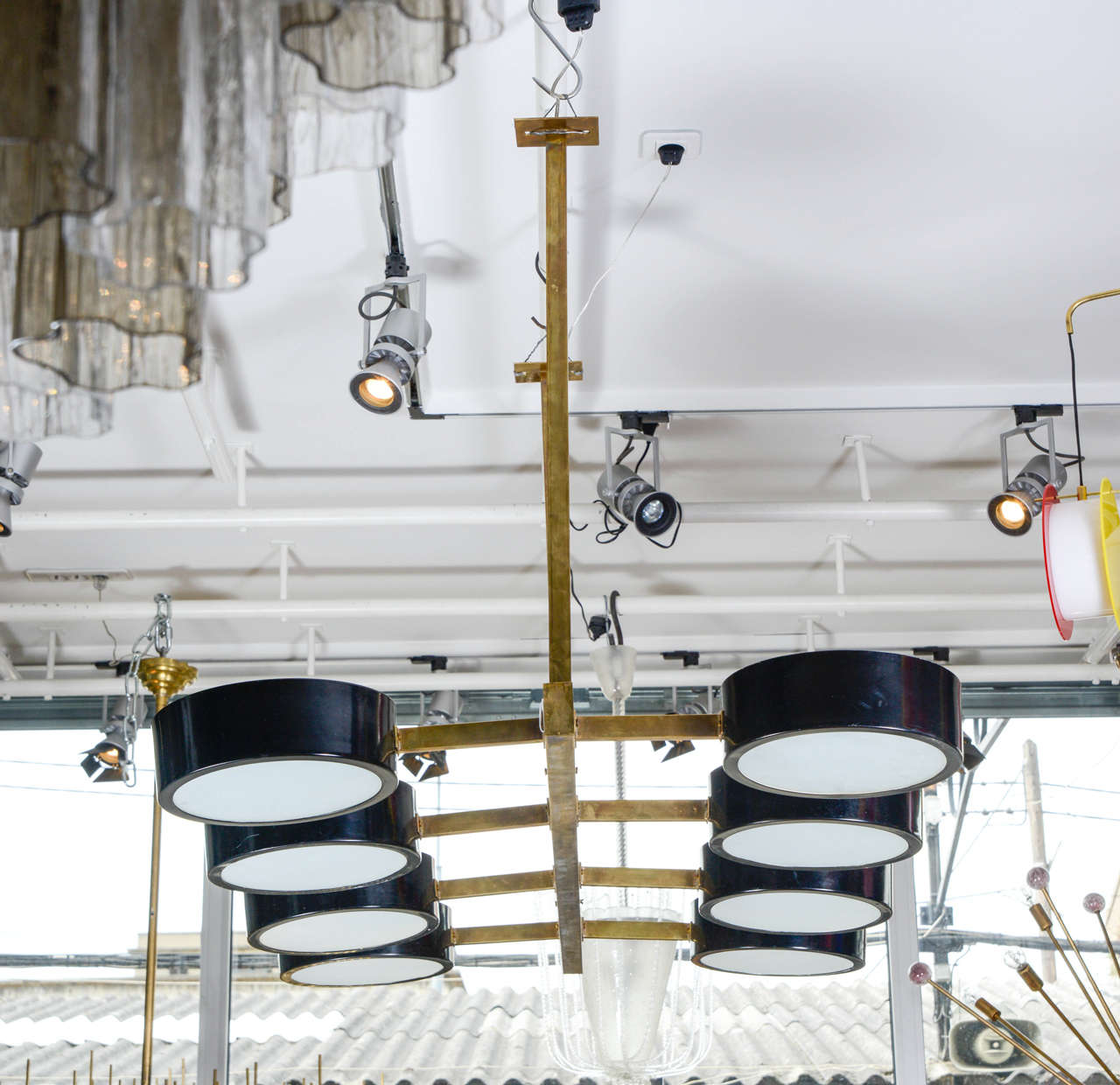 Nice Industrial style chandelier made in Italy in the 1970s.
Made of a brass frame and eight arms of light, this chandelier is finished by circular enameled black metal pieces and sandblasted glasses hiding the bulbs.