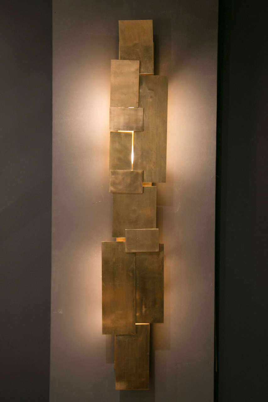 Pair of brass sconces with a tangle of rectangular brass plates, each sconce has four bulbles