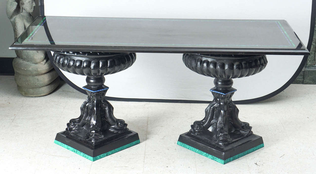 With a slightly ancient Roman feeling this table crafted from black painted neoclassical cast metal urn supports topped with a black marble top inlaid with wide Malachite and smaller Lapis Lazuli line borders has a strong profile or presence in a