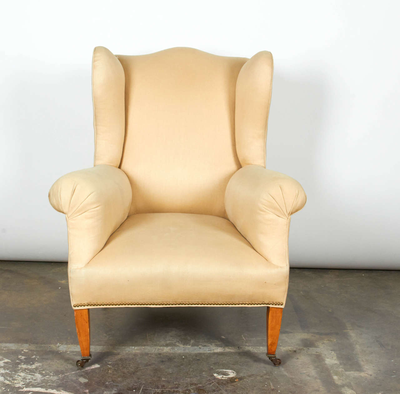20th century Hepplewhite style wing chair with tapered legs on brass casters.

*Not available for sale or to ship in the state of California.