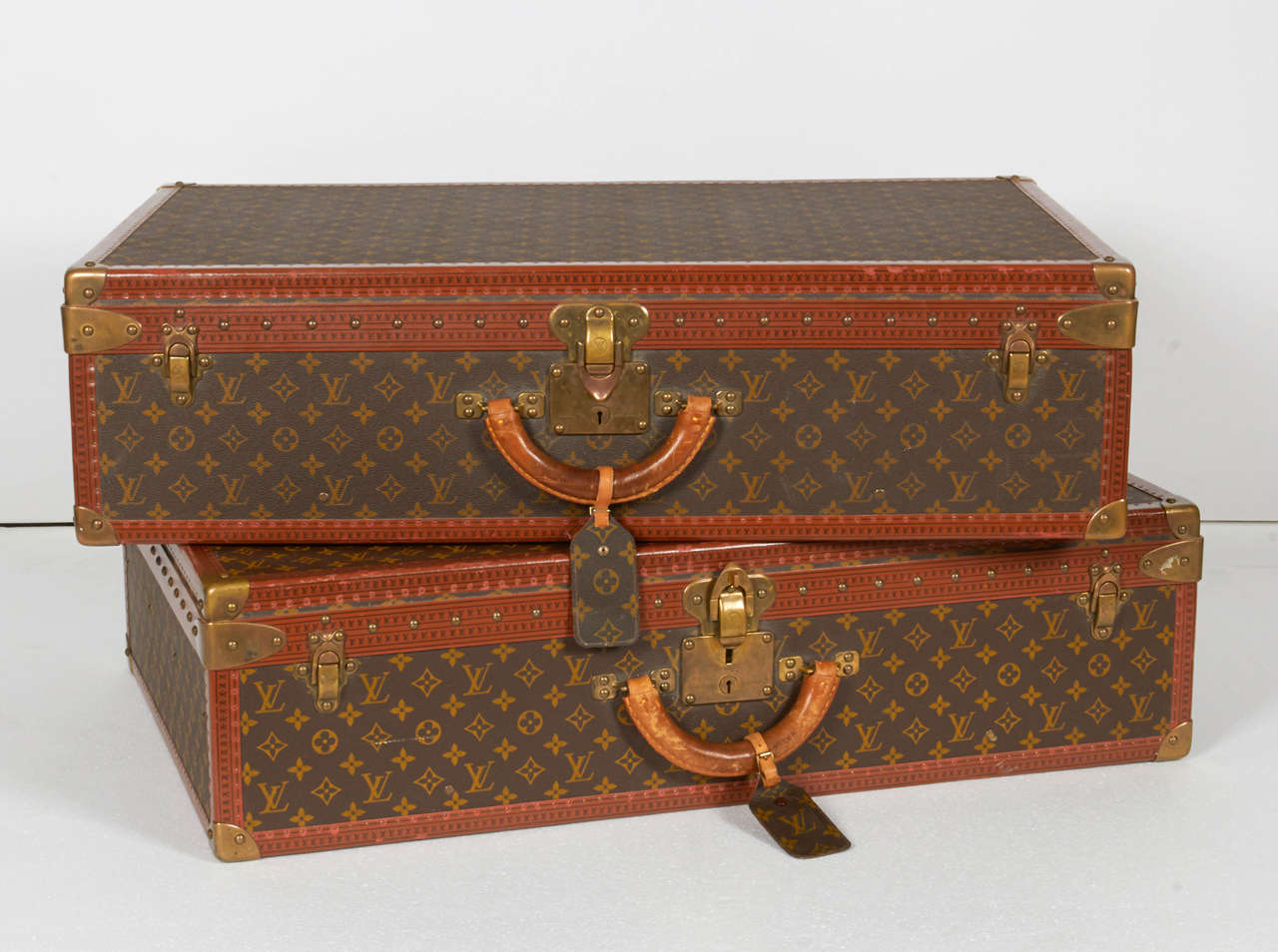 Vintage set of leather luggage trunks by Paris fashion house Louis Vuitton. Suitcase lining and removable interior tray are both made from canvas. Leather trim is reinforced with rivets and golden brass corners. Interior straps and buckles are