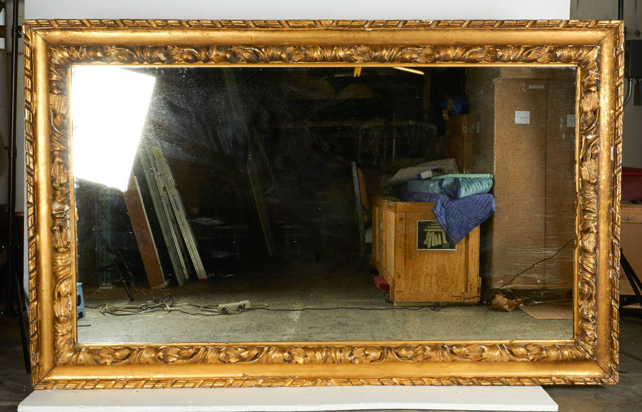A massive mirror to make a commanding statement in your home or project. This 19th century mirror has a beautifully designed plaster frame with hooks to hang vertically. The mirror is a new addition to this antique frame and is done with an antique