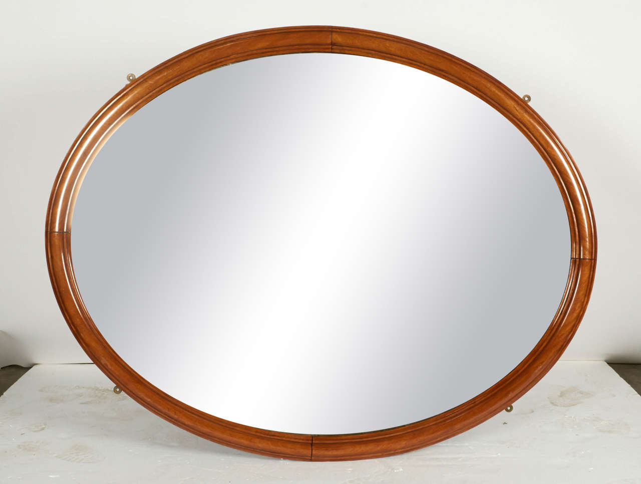 Handsome oak framed mirror with an almost golden wood grain. Four exposed metal brackets were possibly used to secure this mirror to a wall of a ship at sea. Frame is 3