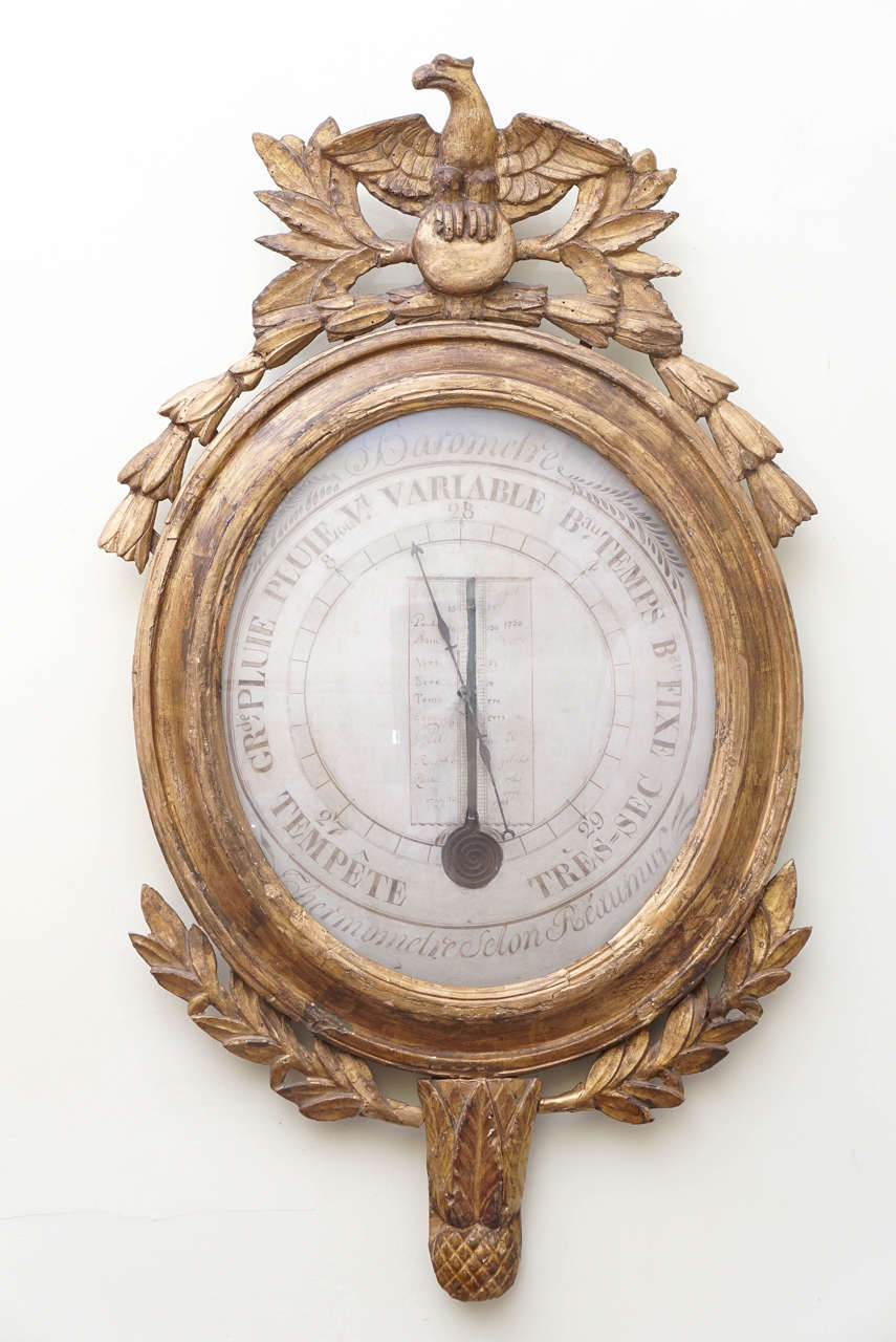 Large Louis XVI style carved giltwood thermometer and barometer in one.
Not a working thermometer, purely decorative at this point. The painted
glass covered wood dial inscribed. 