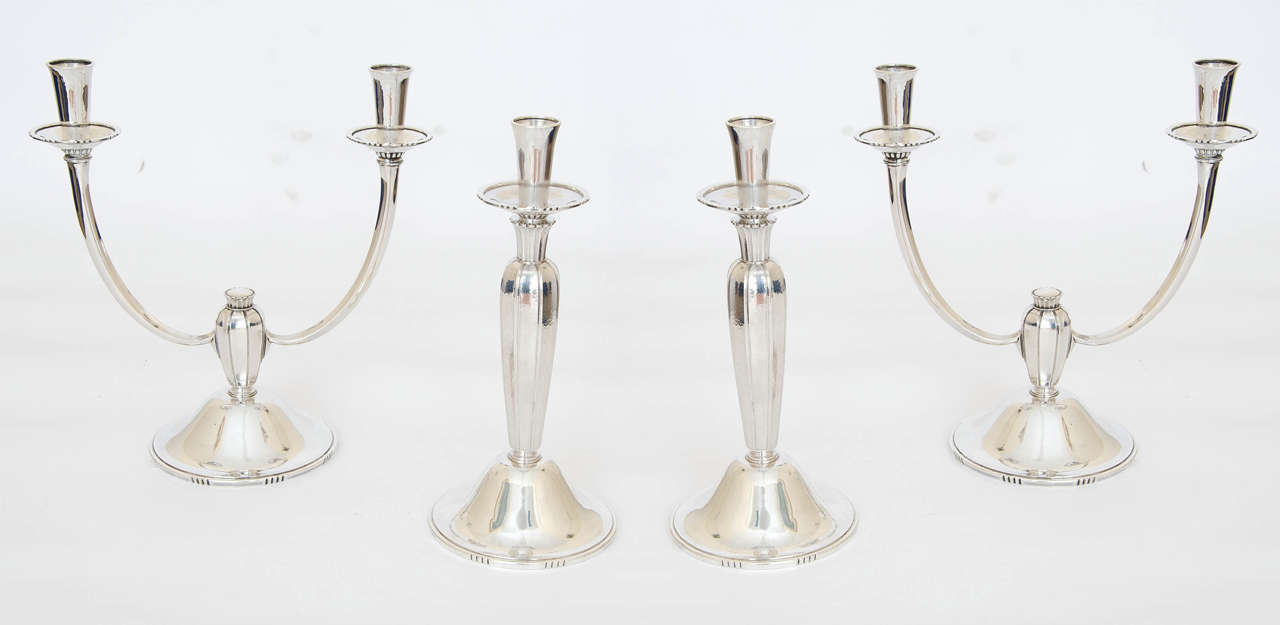 A rare and important Modernist candelabra suite comprising a pair of candlesticks and a pair of candelabra. The suite was made by the renowned silversmith Robert Edgar Stone (1903-1990) and retailed by the Royal Goldsmith & Silversmith, Garrard