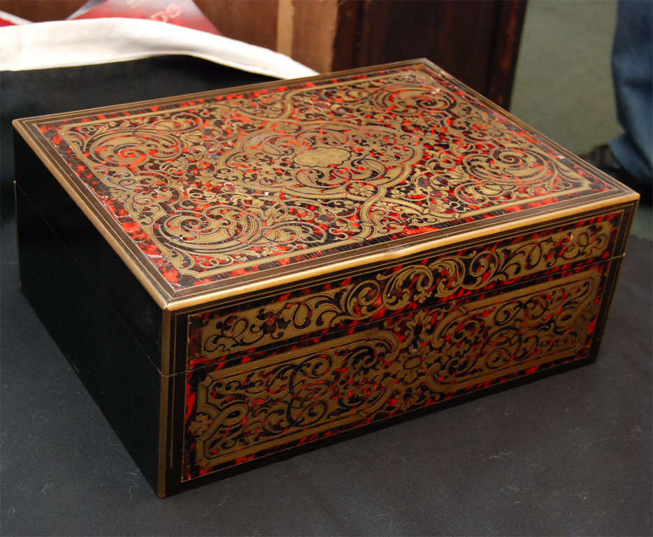 A antiques Boulle box with inlaid etched brass, and tortoise shell, and lined on the inside with Mori silk.