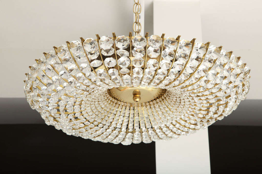 A very striking circular beaded chandelier composed of faceted crystal beads on a brass frame a center brass plate. Can be flush mounted or hung on a chain.