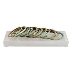 Collection of 17 Bronze Bracelets on Lucite Stand