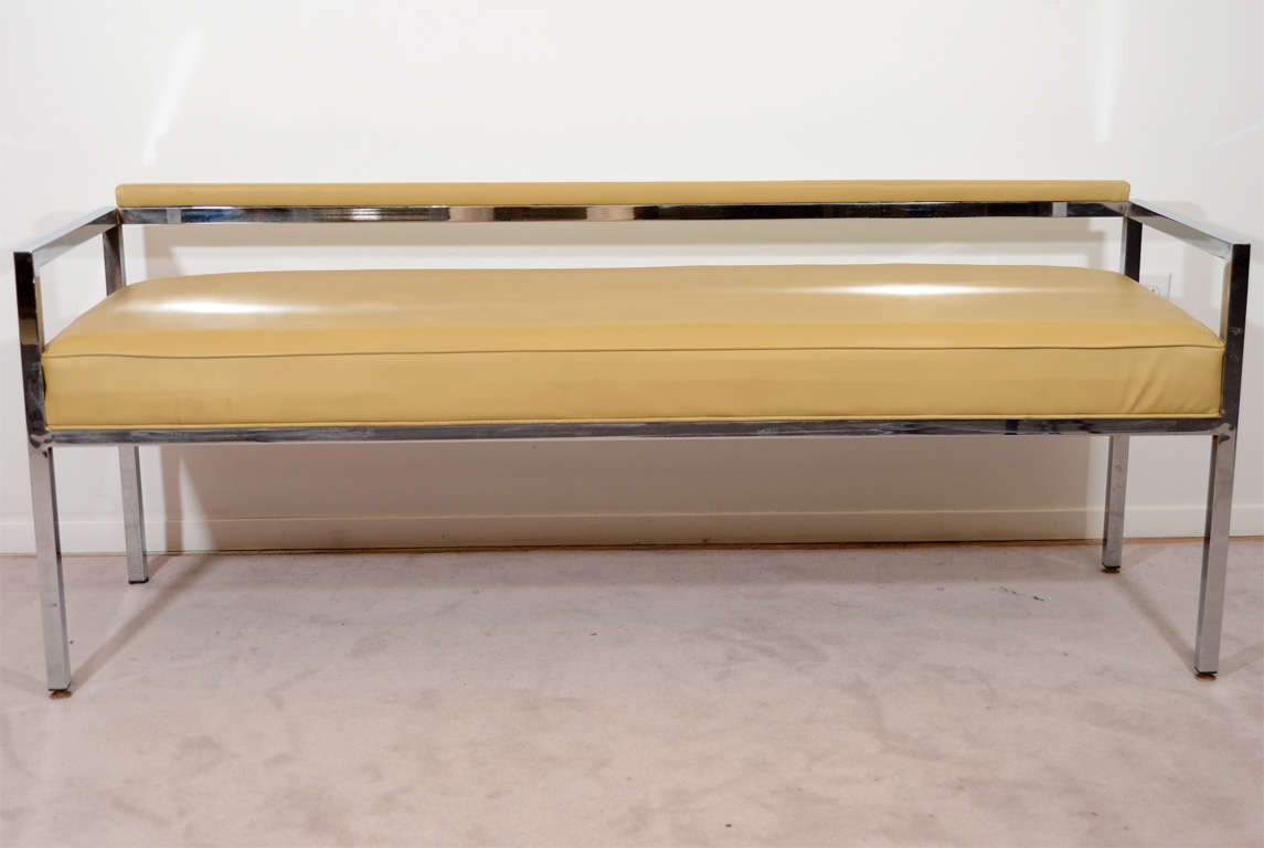 A vintage low-back bench with tan vinyl upholstery and a chrome frame. The piece is by noted designer Milo Baughman