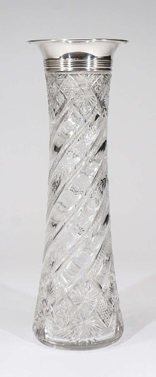 Diese sehr hohe und elegant geformte Kristallvase zeichnet sich durch eine Kombination von geometrischen Schliffen aus der amerikanischen Brillantperiode aus, die sich mit floralen Verzierungen in Kupferradgravur auf einem spiralförmig geschliffenen