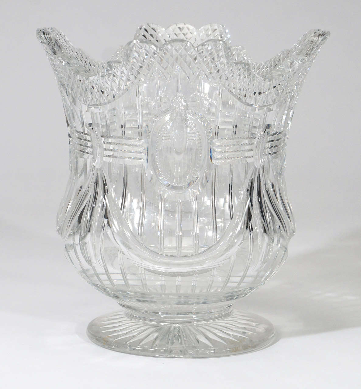 This is an extraordinary example of Thomas Webb and Sons masterful blown crystal and wheel cutting. The heavy blank weighs over 15 pounds and is expertly cut in a Georgian design of swags and central medallions.The cutting is deep, well executed and