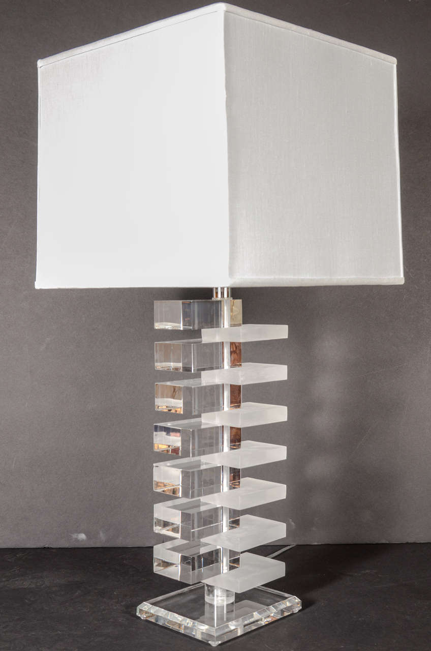 Modernist Skyscraper style table lamp in alternating frosted and clear lucite stepped design with a beveled clear lucite base. Includes new custom shade and has been newly rewired.