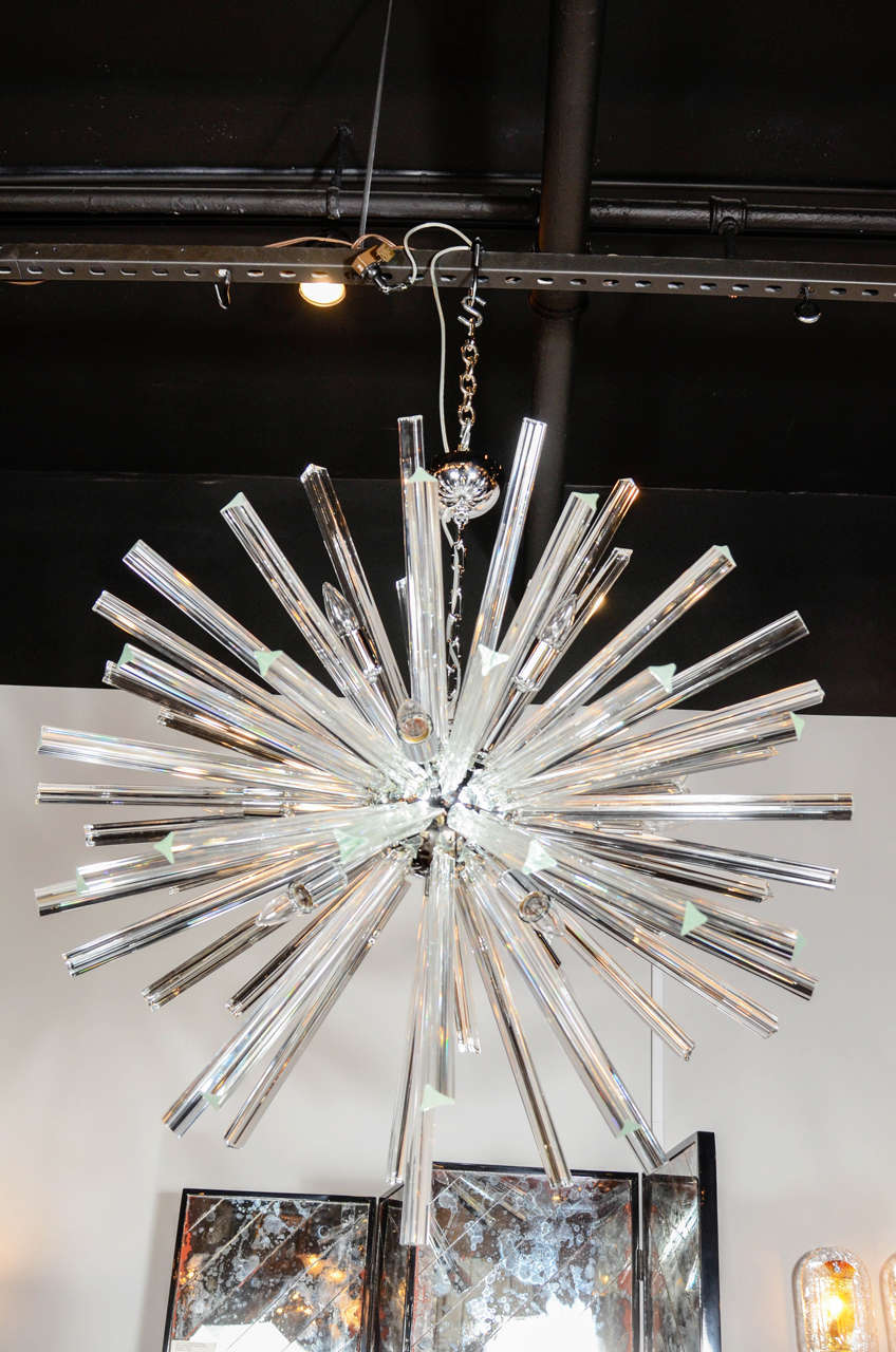 This gorgeous Sputnik chandelier was hand blown in Murano, Italy- the island off the coast of Venice renowned for centuries for its superlative glass production. It consists of a series of Murano Glass Triedre rods emanating from a spherical