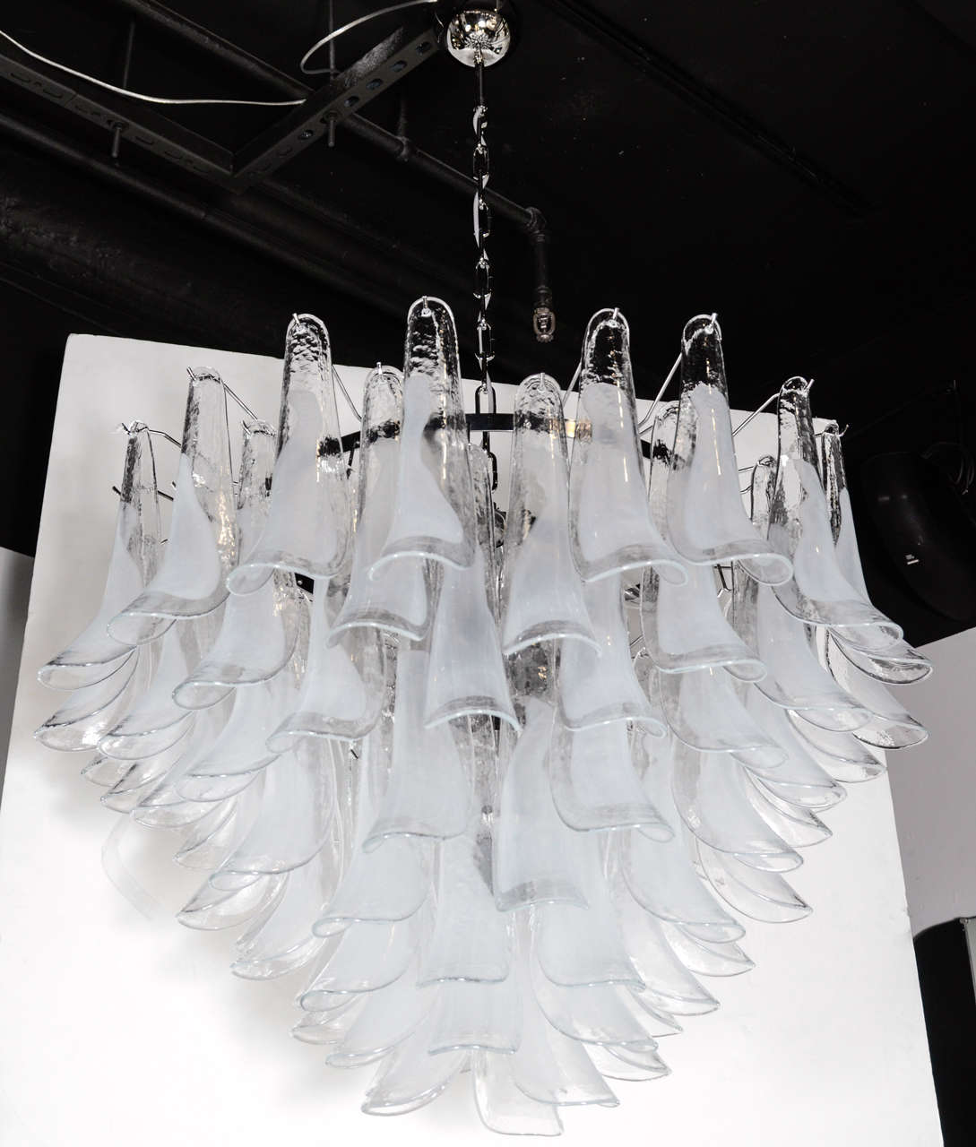 This impressive Mid-Century chandelier consists of a series of feather like Murano Glass shades suspended from a frame that holds twelve chandelier bulbs. This chandelier would make a real statement and would suit a variety of decor's. This piece