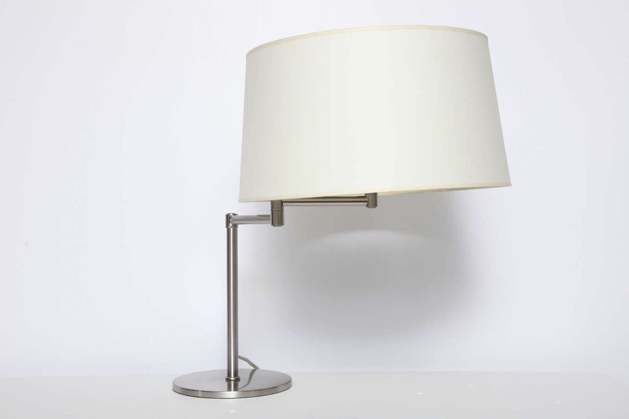 Swing-arm desk lamp in brushed metal finish.  USA, circa 1990.  Includes off-white paper drum shade.  Takes one standard U.S. bulb, 75 watts max.

Dimensions: 

22.5 inch lamp height
8 inch base diameter
15 inch shade top diameter
16.5 inch