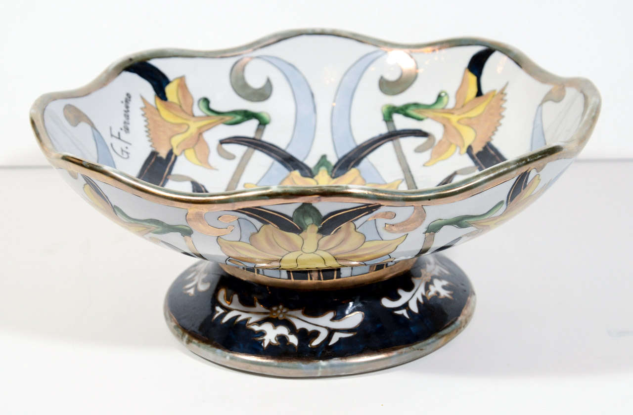 Superb ceramic earthenware footed bowl or centerpiece. The bowl is all hand painted with daffodils motif. It has scalloped borders with white gold leaf details and features grey and black stylized fronds  over a white background. Signed by the