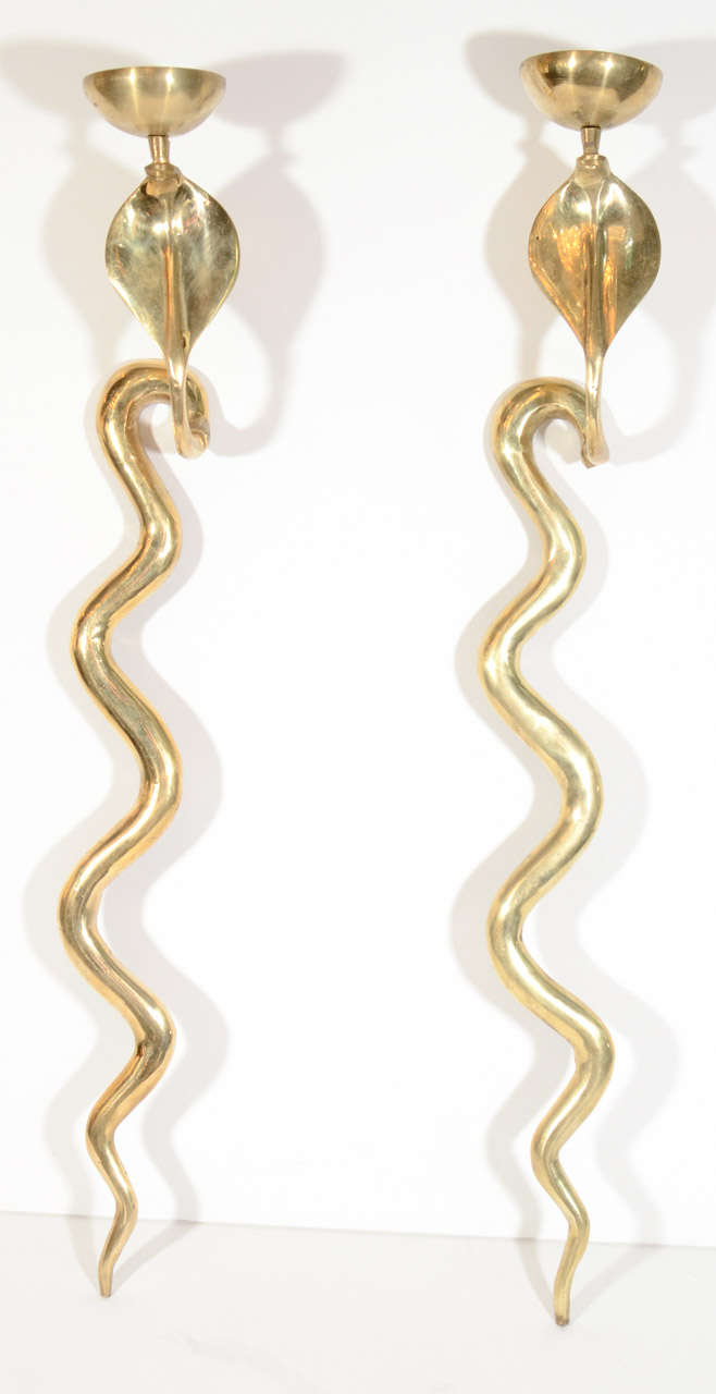 Pair of superb wall sconce candelabras in solid brass.  Highly stylized king cobra design with scrolled body form and hooded head details.