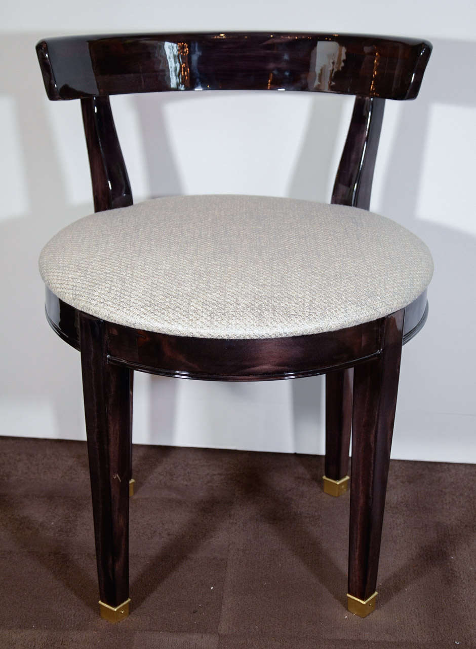 Elegant Art Deco stool or vanity chair with in ebonized walnut wood.
The chair has ample round seat and has low back design with curved or klismos form. Newly upholstered in textured creme boucle  fabric with woven platinum fibers.  Legs have four