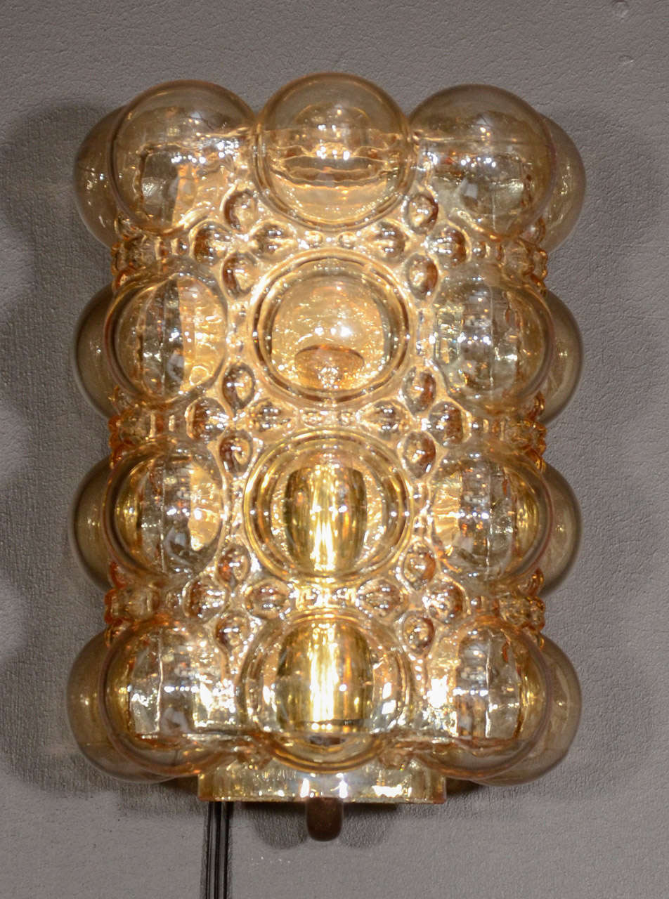 Pair of mid century modern hand blown glass sconces. Spherical texturized glass in amber tones. Fitted with dark brass and black enameled backplate and fittings & one light each.