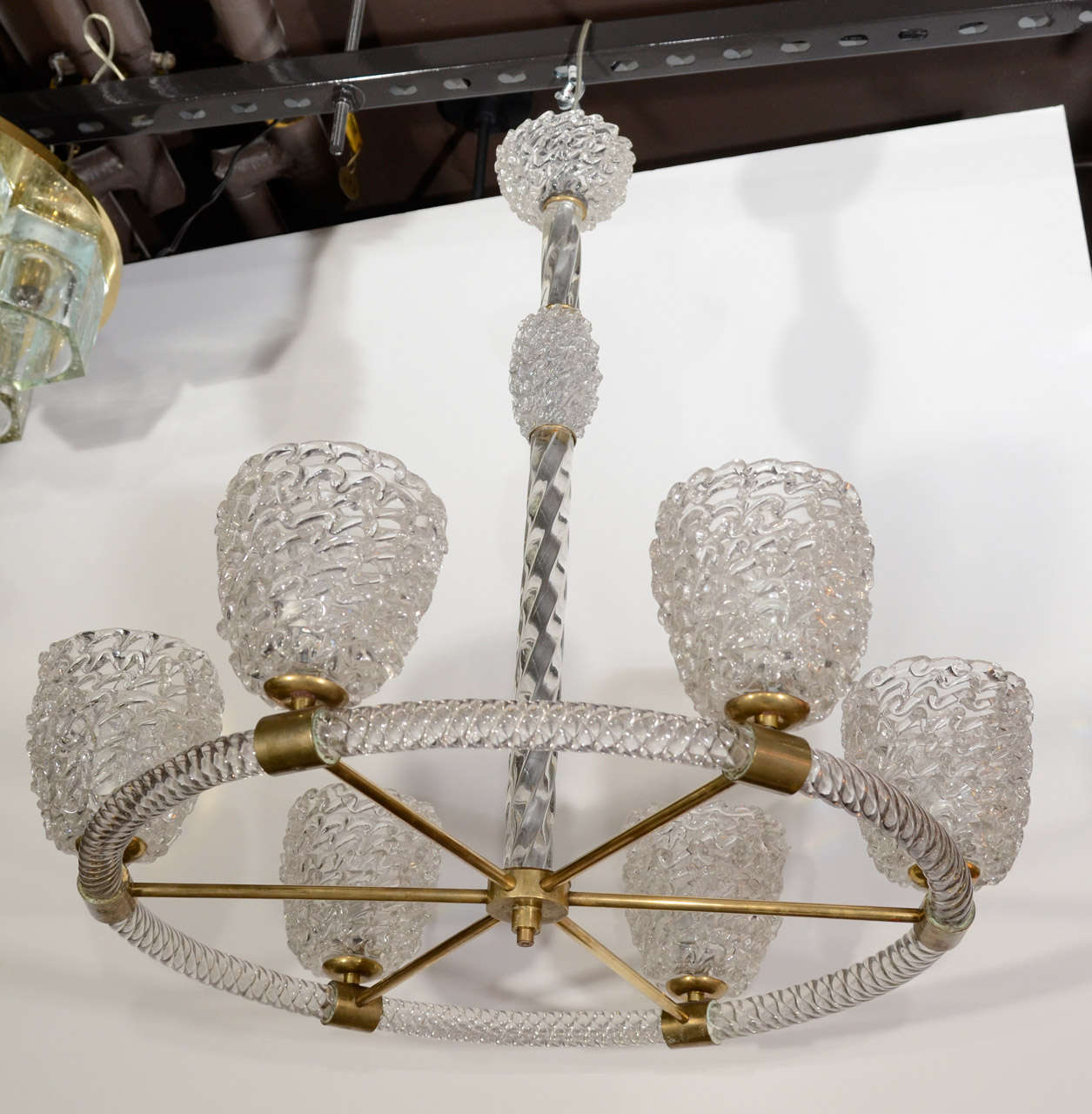 Exquisite hand blown Murano glass chandelier with circular design. The chandelier features six textured glass globe shades with hand formed wave or rippled patterns held by stylized bronze fittings. Frame is comprised of spiral blown glass elements