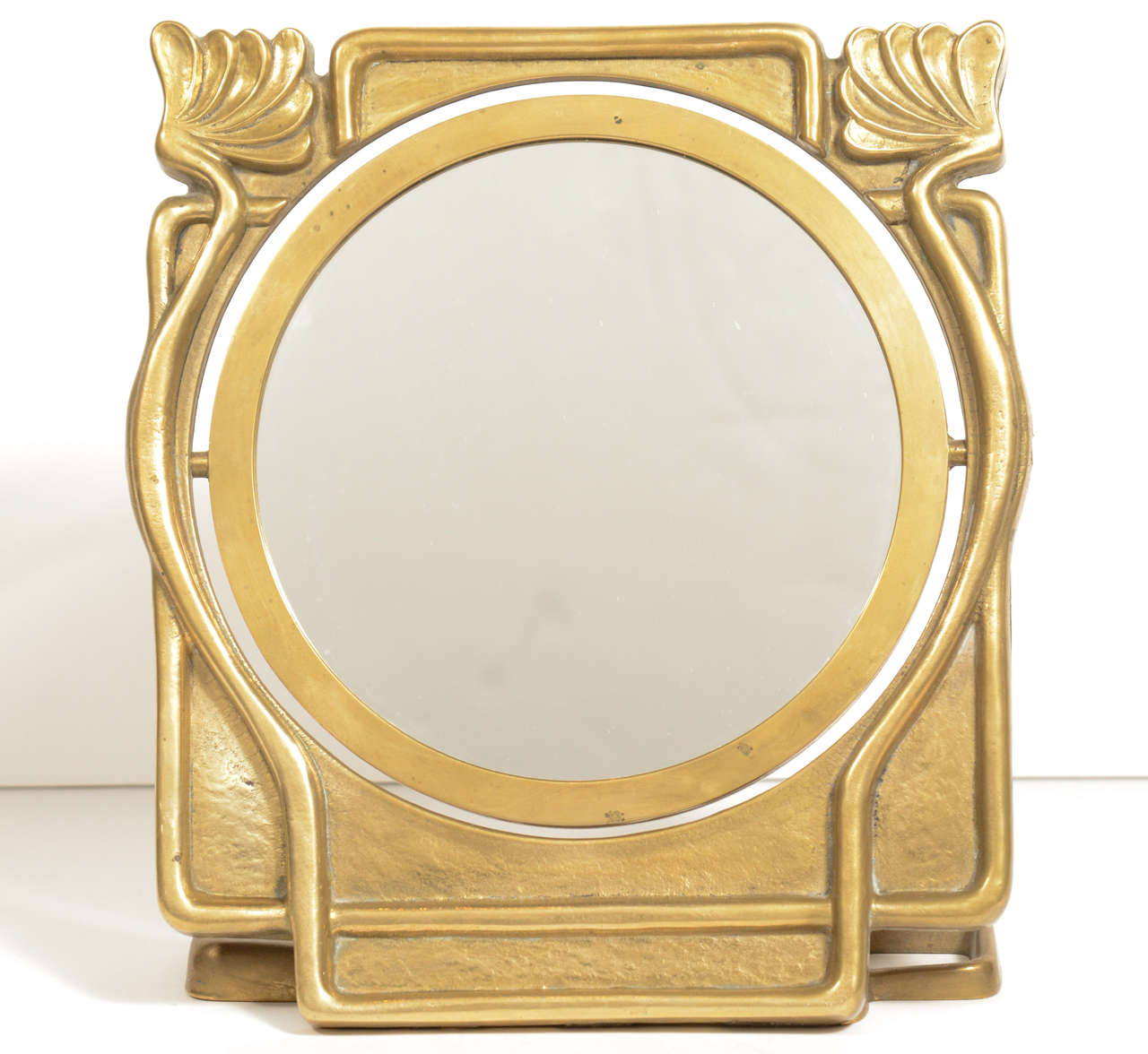 Outstanding Art Nouveau vanity top mirror made of hand cast bronze. Highly stylized modern and streamline design with floral stem details depictive of the Era. The center features a revolving mirror (mirrored on both sides).
