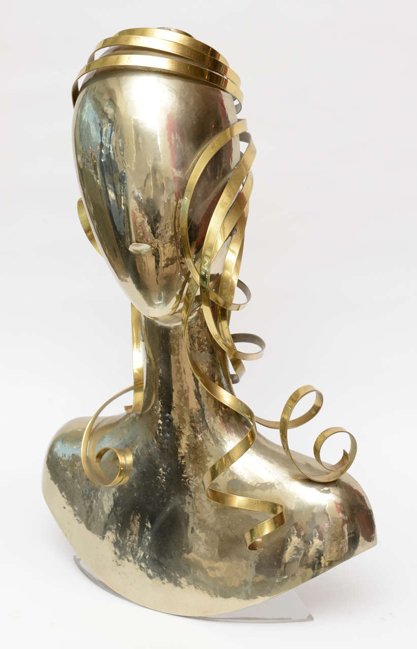 The ribbons of cascading hair made out of brass add dimension to the hand hammered Alpaca silver faceless form executed by the Austrian sculptor; Karl Schmidt. He worked for Hagenhauer until 1987 and then did his own designs. This is from 1989. It